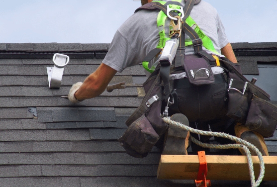 Professional roof repair in Duluth MN: technician replacing shingles to prevent water damage and leaks.